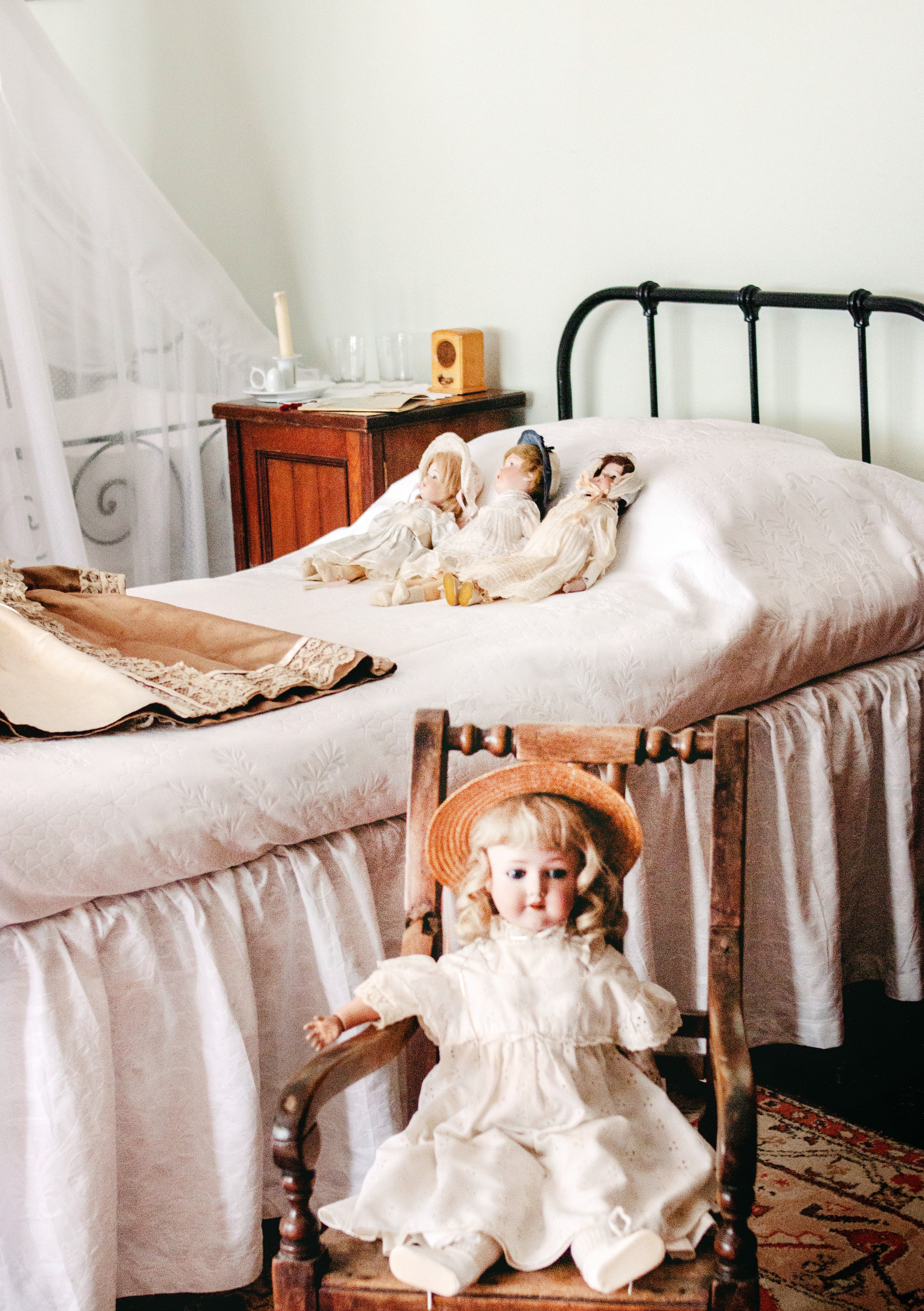 antique dolls on a bed